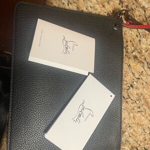 Christian Loubuotin wristlet. 8”wide x 61/2 “ tall.